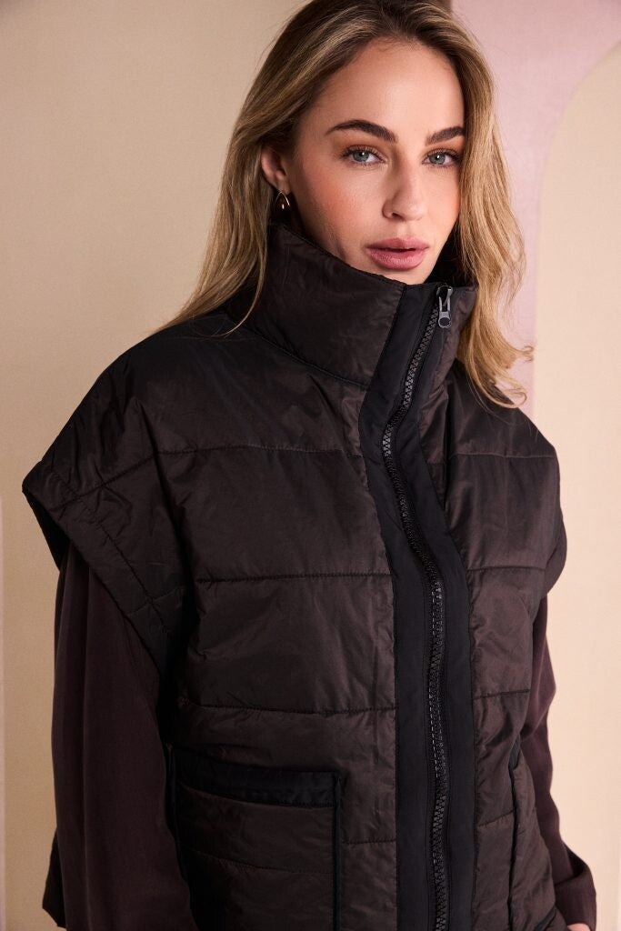 Naya women’s short padded waistcoat styled with wide leg trousers and layered top